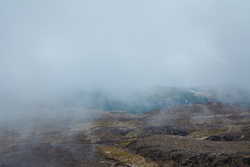 Thick fog creeping over desolated lava fields on the slopes of Mt Ruapehu. Tongariro National Park, New Zealand