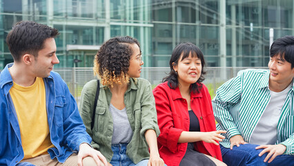 ベンチに座って話す多国籍学生グループ