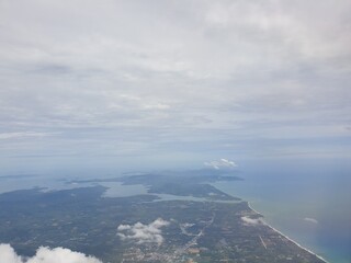 Top view from the plane, overlooking the sea, islands and wide blue sky.