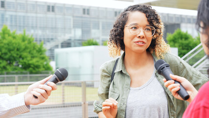 African woman being interviewed on the street by the media.