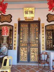 Photo of a door in a Chinese temple, in golden tones.