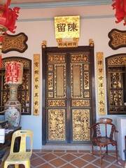 Photo of a door in a Chinese temple, in golden tones.