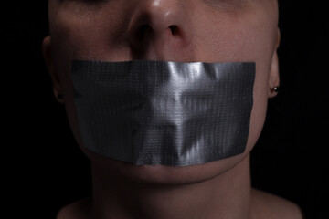 Close up of woman's taped mouth, concept of violence, freedom of speech