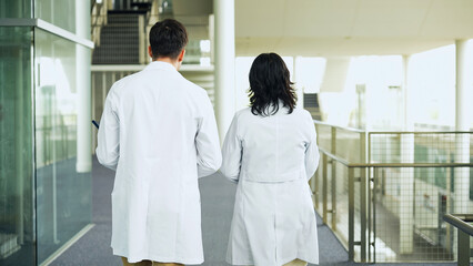 Obraz premium Multinational group walking in the lobby wearing white coats.