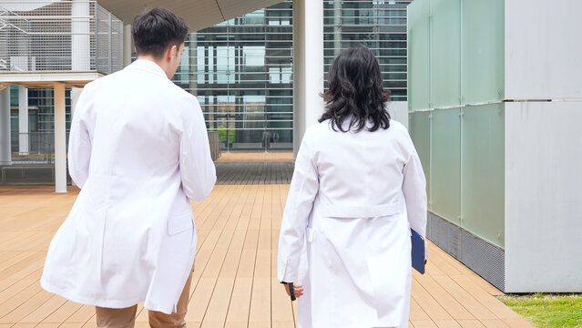 Multinational group walking in the lobby wearing white coats.