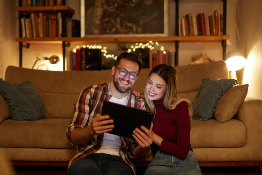 Young Couple Spending Evening At Home Using Digital Tablet