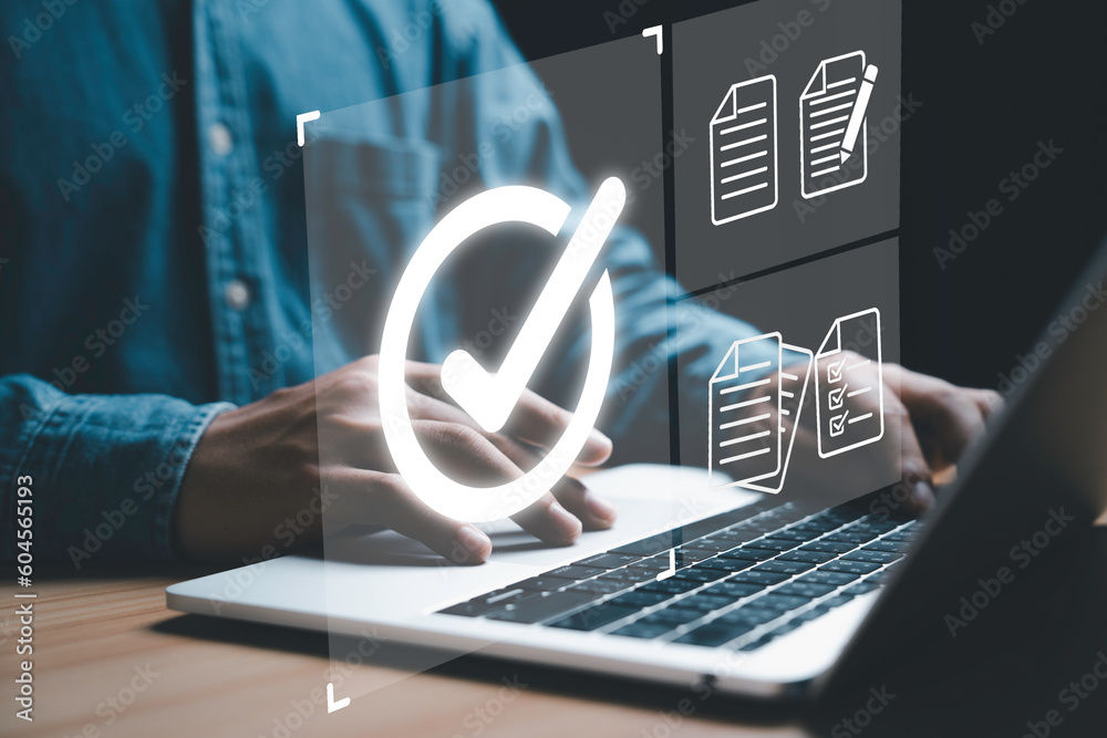 Poster Businessman using computer laptop with correct sign mark and document icon for online quality control document checking concept.