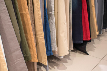 line up pants of different colors in the market. hanging on a rack. a  row of pants. concept of buying, selling, shopping, and fashion. stock images, selective focus. vienna, austria, 16 may 2023