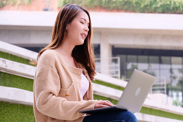 Smiling girl sitting on a laptop.