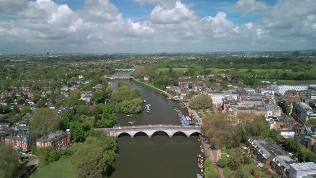 The drone aerial footage of Thames River runs through Richmond town center on the east bank with its neighboring district of East Twickenham to the west, London, UK.