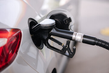 Car refueling at gas station. Petrol pump filling fuel nozzle in fuel tank of car at gas station....