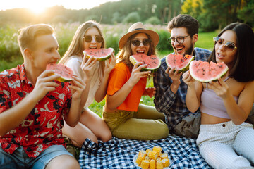 Group of friends  have fun together and eating watermelon in hot summer day. People, lifestyle, travel, nature and vacations concept. 