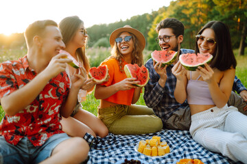 Group of friends  have fun together and eating watermelon in hot summer day. People, lifestyle, travel, nature and vacations concept. 