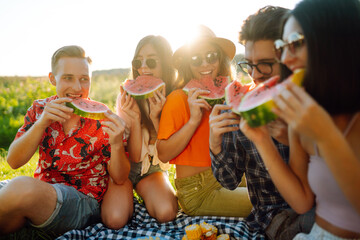 Group of friends  have fun together and eating watermelon in hot summer day. People, lifestyle, travel, nature and vacations concept. 