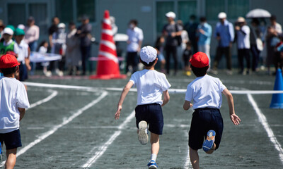小学校の運動会で短距離走をしている学生達の後ろ姿