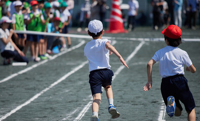 Fototapeta na wymiar 小学校の運動会で短距離走をしている学生達の後ろ姿