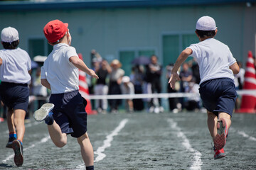 小学校の運動会で短距離走をしている学生達の後ろ姿