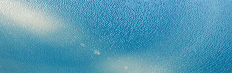Water surface. Blue water background with soft waves. Texture of the water surface.