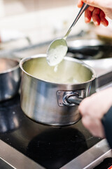 Chef hands cooking cheese sauce in the restaurant kitchen