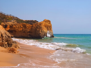 typical Algarve beach with red cliffs Praia Maria Luisa in Portugal