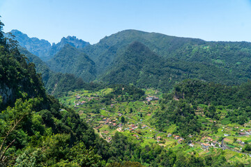 Obraz premium Mountain landscape with vegetation beautiful background of Madeira mountains. Green landscape cloudy sky
