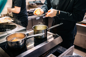 Chef hands cooking cheese sauce in the restaurant kitchen