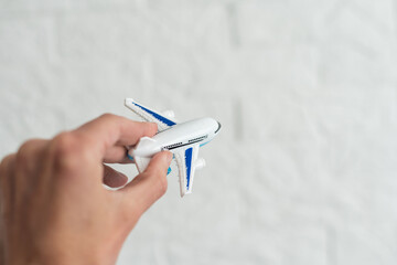 hand holding airplane toy model isolated on white background.