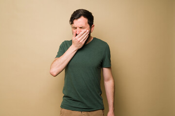 Exhausted latin man feeling sleepy looking tired and yawning