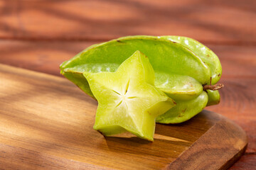 Fototapeta premium Star fruit or Carambola Green - Averrhoa Carambola; Photo On Wooden Background