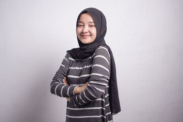 Fototapeta premium Cheerful beautiful Asian muslim woman in brown sweater crossing hands and smiling at camera isolated over white background