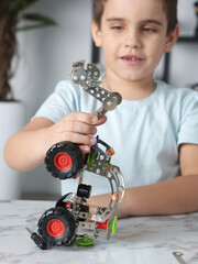 little preteen boy play with steel mechanical constructor set close up photo