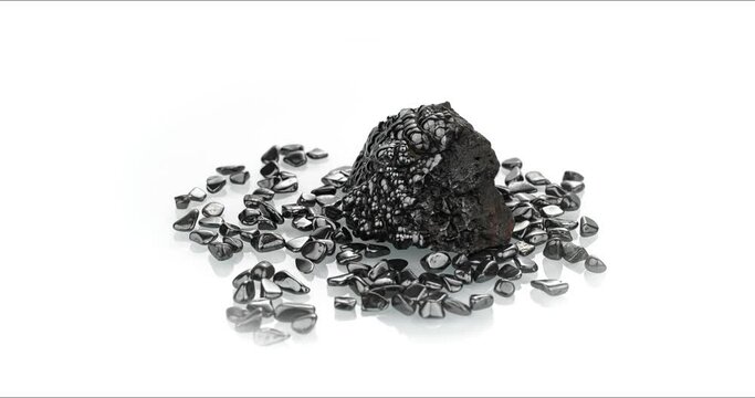 rough hematite and polished chips 360&deg; rotation in 4k. macro detail texture background. close-up raw rough unpolished semi-precious gemstone