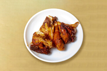 Fried chicken wings in white plate on wooden table. Top view