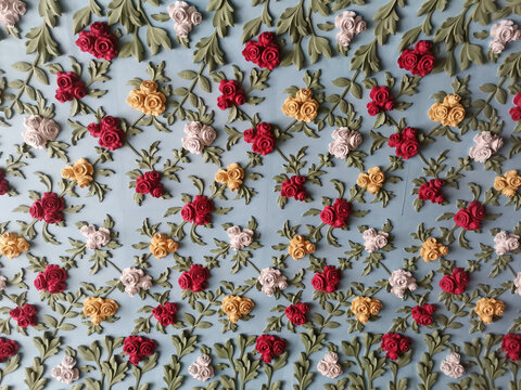 Roses garden arch ceiling pattern detail with red, yellow and white floral clay moulding shapes on light blue background