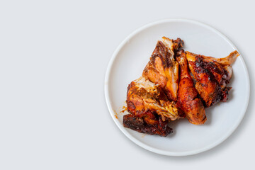 Fried chicken wings on a white plate on a white background with copy space