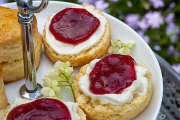 freshly baked scones with clotted cream and raspberry jam, close up