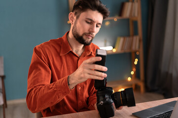 Portrait of a student photographer watching an online course for photographers. Digital camera equipment and settings in the home office