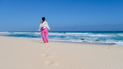 Asian women relaxing on the beach at De Hoop Nature Reserve South Africa Western Cape, the most beautiful beach in South Africa with the white dunes part of the garden route. 