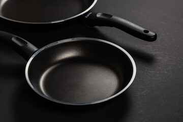 Two black frying pan on dark background, close-up,