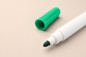 Bright green marker on beige background, closeup. Space for text