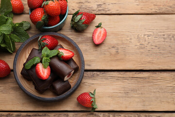 Delicious glazed curd snacks with fresh strawberries and mint on wooden table, flat lay. Space for text