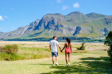 A couple man and women mid age in front of their lodge during a vacation in South Africa, Mountains and grassland near Hermanus at the Garden Route Western Cape South Africa Whale coast. 