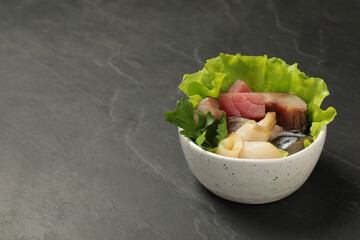 Delicious mackerel, squid and tuna served with lettuce and parsley on grey table, space for text. Tasty sashimi dish