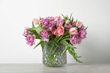 Fototapeta premium Beautiful bouquet of colorful tulip flowers on wooden table