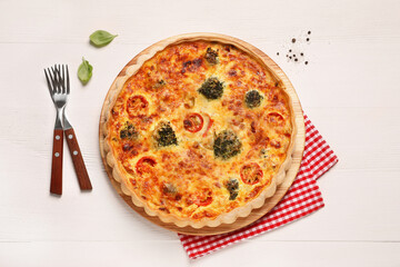 Delicious homemade vegetable quiche and forks on wooden table, flat lay