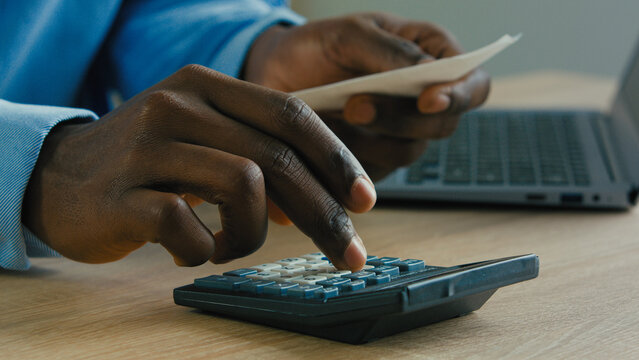 Close up male hands calculating incomes bills expenses pay for loan businessman accountant using calculator check credit balance manage budget business household expenses accounting managing finances - Powered by Adobe