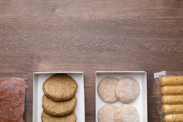 Different vegan products on wooden table, flat lay. Space for text