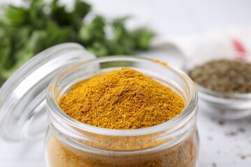 Glass jar with curry powder, closeup view