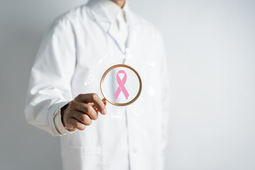 Doctor holding magnifier focus to virtual pink ribbon cancer, Breast cancer awareness and health care medical check-up concept.