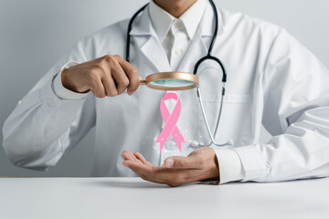 Doctor holding virtual pink ribbon cancer, Breast cancer awareness and health care medical check-up concept.